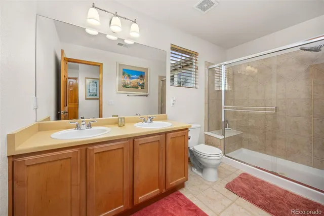 a bathroom with a sink a toilet a mirror and shower