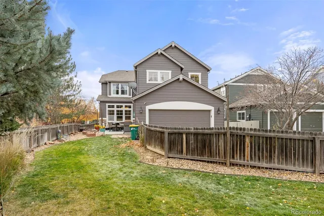 a view of a house with a big yard and large trees