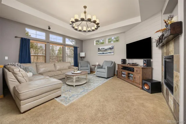 a living room with furniture a flat screen tv and a chandelier