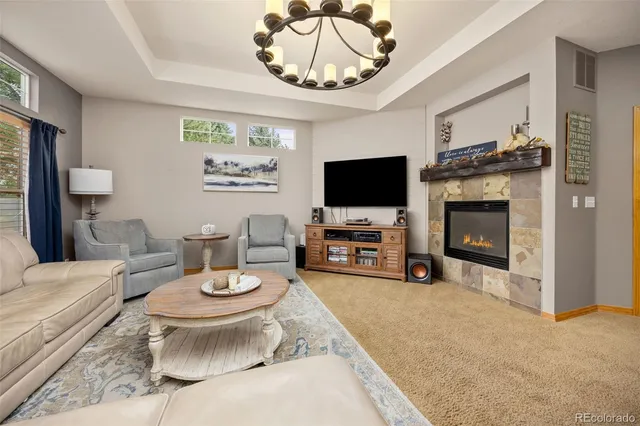 a living room with furniture a flat screen tv and a fireplace