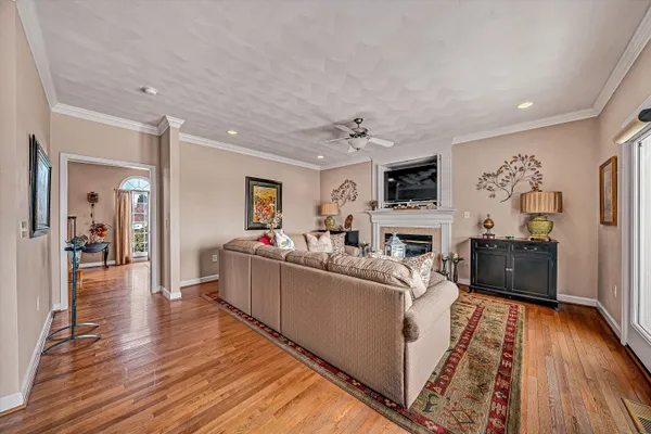 a dining room with wooden floor a chandelier a wooden table and chairs