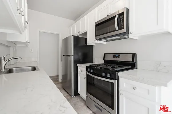 a kitchen with stainless steel appliances a stove microwave and sink