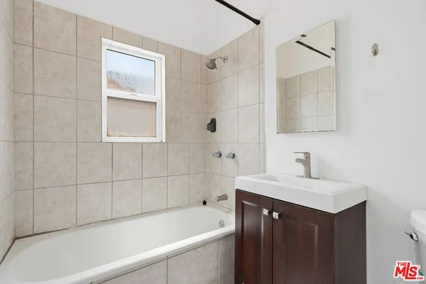 a bathroom with a sink vanity tub and shower