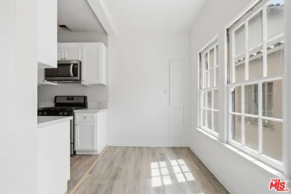 a view of a kitchen with wooden floor and electronic appliances