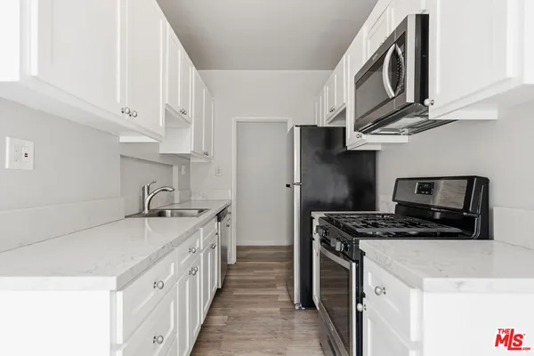 a kitchen with stainless steel appliances a stove a sink and a refrigerator