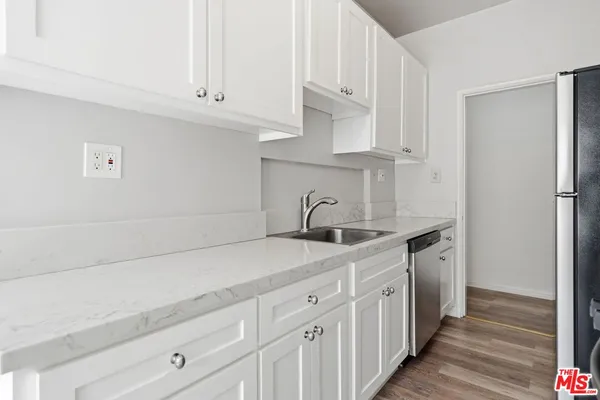 a kitchen with stainless steel appliances white cabinets and a sink