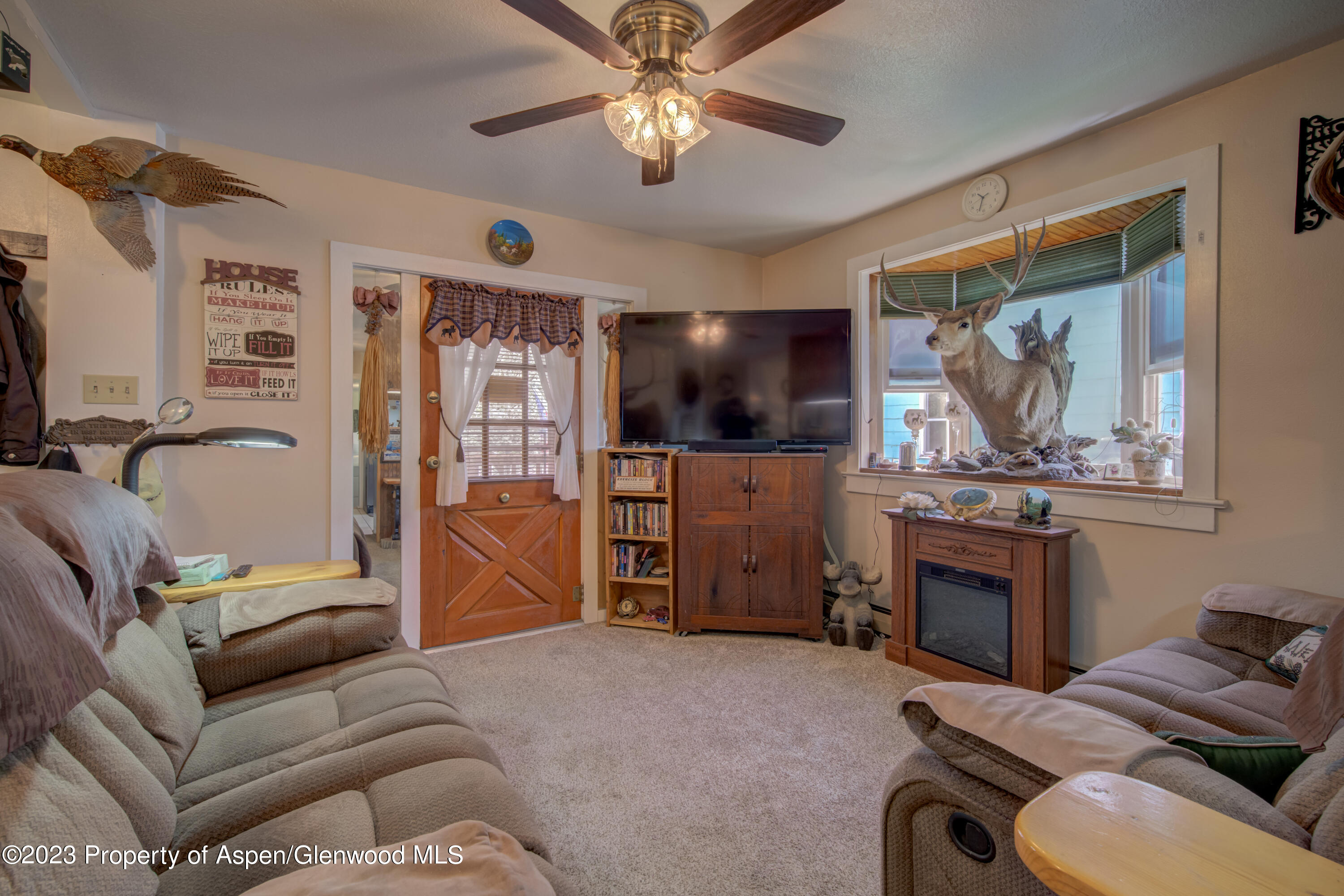 690 Pershing Street Craig, CO 81625 - Photo 28 of 72 a living room with furniture a ceiling fan and a window