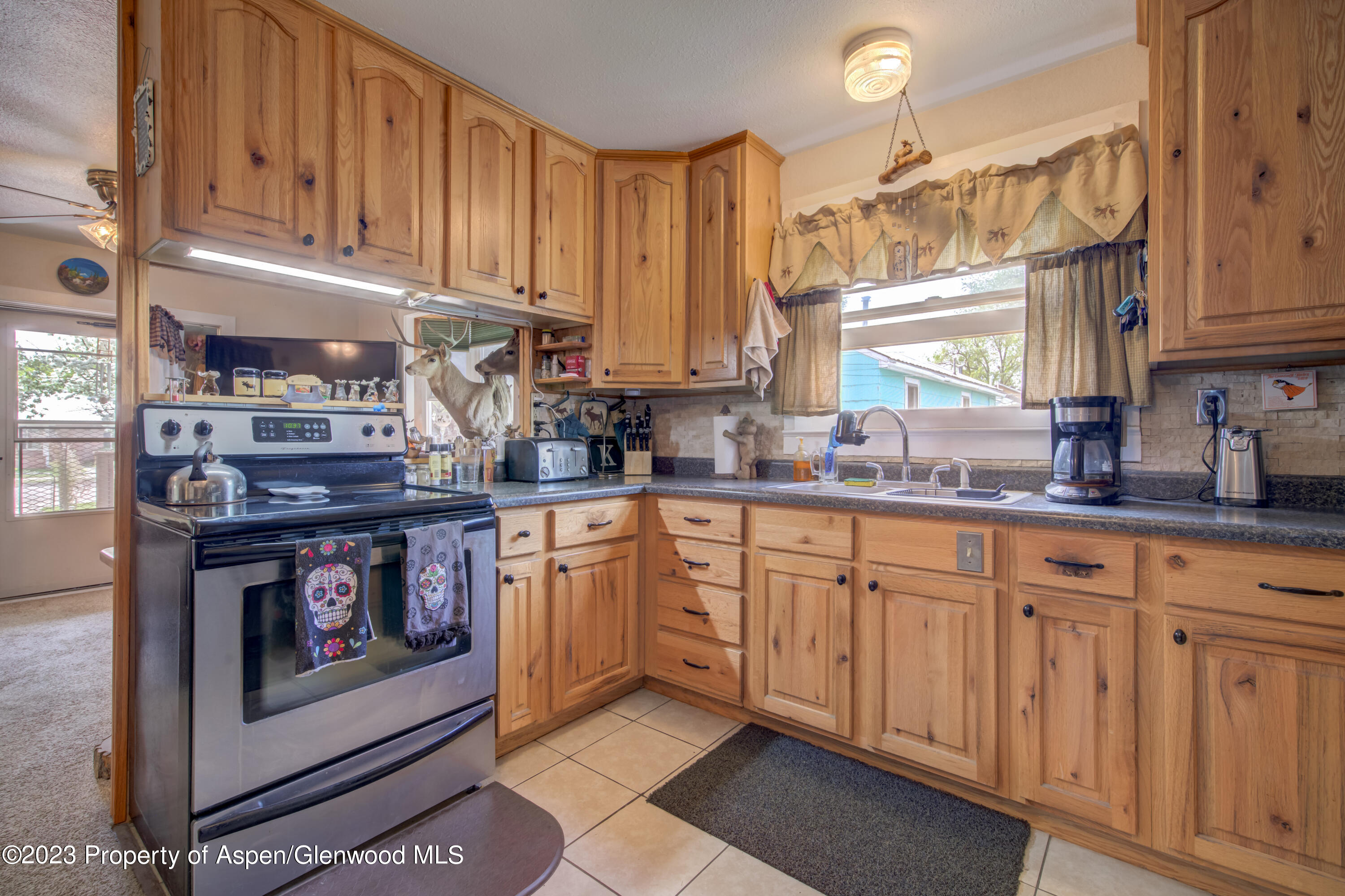690 Pershing Street Craig, CO 81625 - Photo 30 of 72 a kitchen with stainless steel appliances granite countertop a stove a sink and a microwave