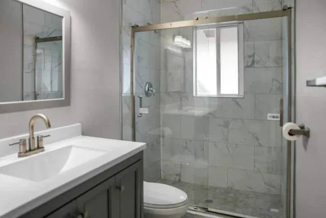 a bathroom with a sink toilet a mirror and shower