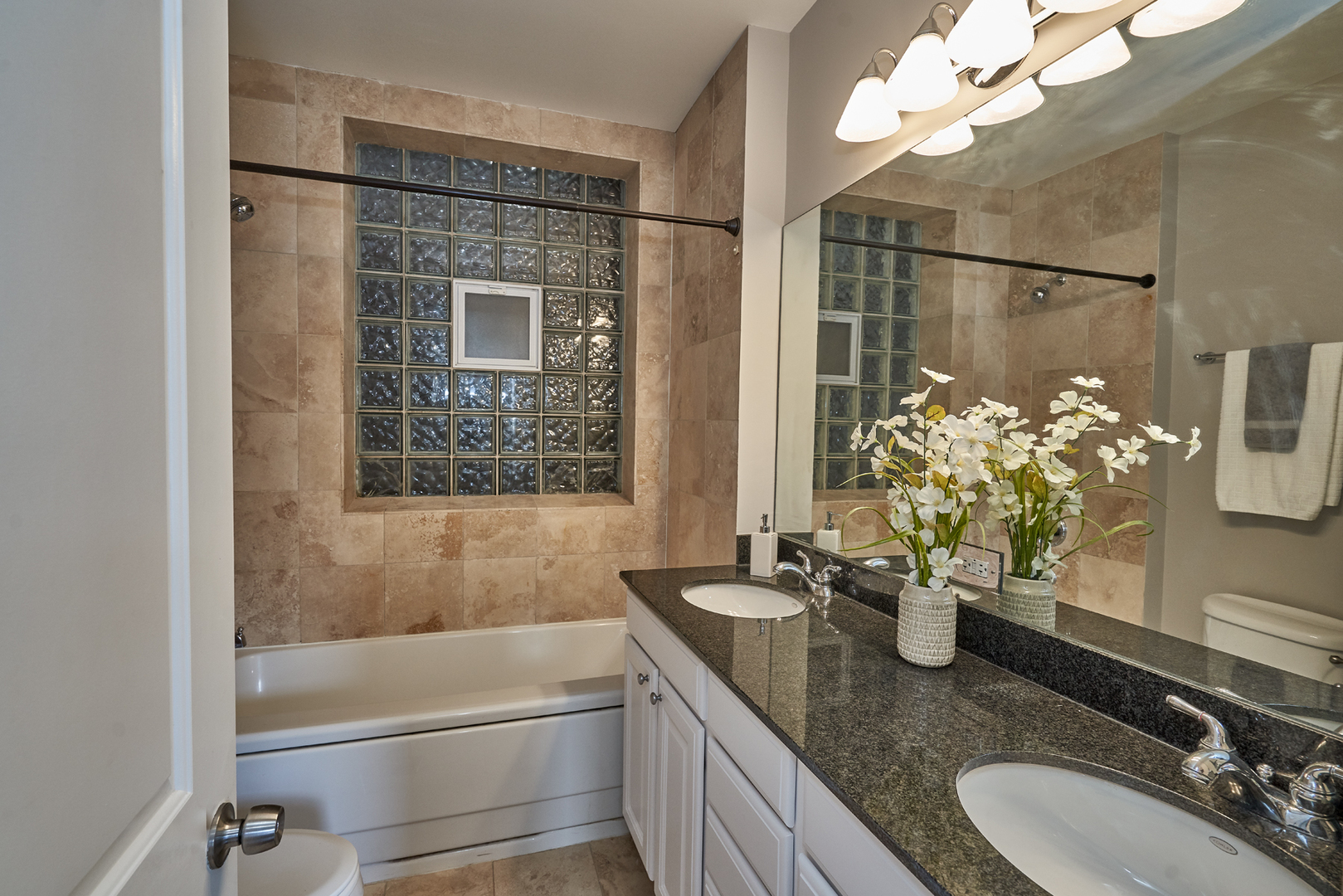 2801 North Seminary Avenue, Unit 1S Chicago, IL 60657 - Photo 11 of 21 a bathroom with a granite countertop sink a mirror and a bathtub