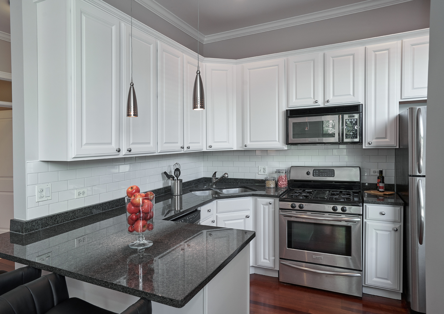 2801 North Seminary Avenue, Unit 1S Chicago, IL 60657 - Photo 8 of 21 a kitchen with stainless steel appliances granite countertop a stove a sink dishwasher and microwave with wooden cabinets