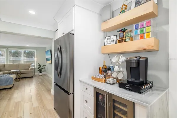 a kitchen with stainless steel appliances granite countertop a refrigerator a stove and a sink with wooden floor