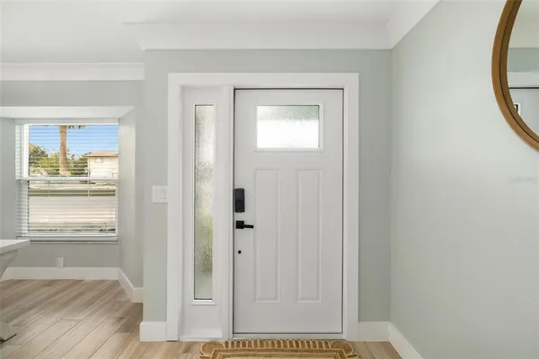a view of a hallway with wooden floor and a bathroom