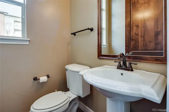 a bathroom with a sink a toilet and mirror