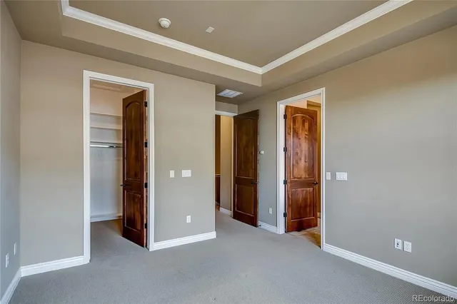 an empty room with closet and a hallway