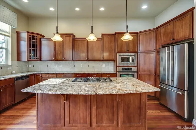 a kitchen with kitchen island a large counter top space appliances and cabinets