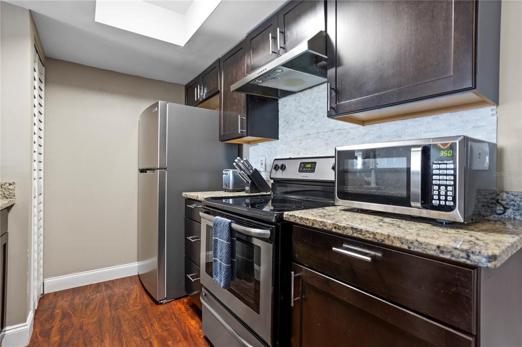 2749 North Poinciana Boulevard, Unit 15 Kissimmee, FL 34746 - Photo 11 of 36 a kitchen with stainless steel appliances granite countertop a stove and a refrigerator