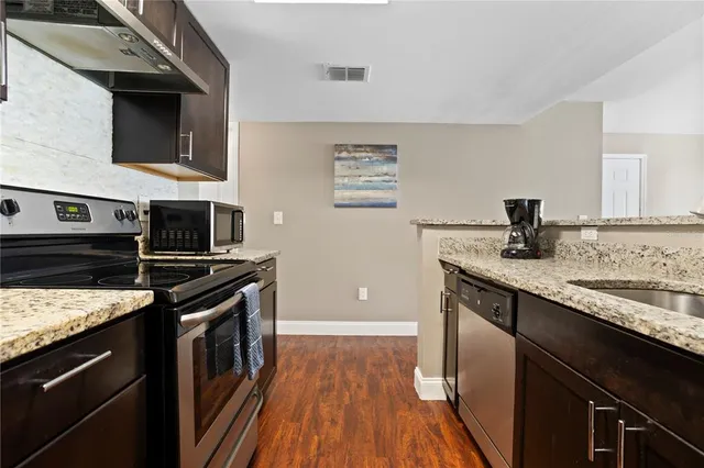 a kitchen with stainless steel appliances granite countertop a stove and a sink