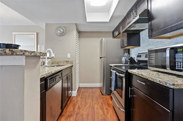 a kitchen with stainless steel appliances granite countertop a sink stove and refrigerator
