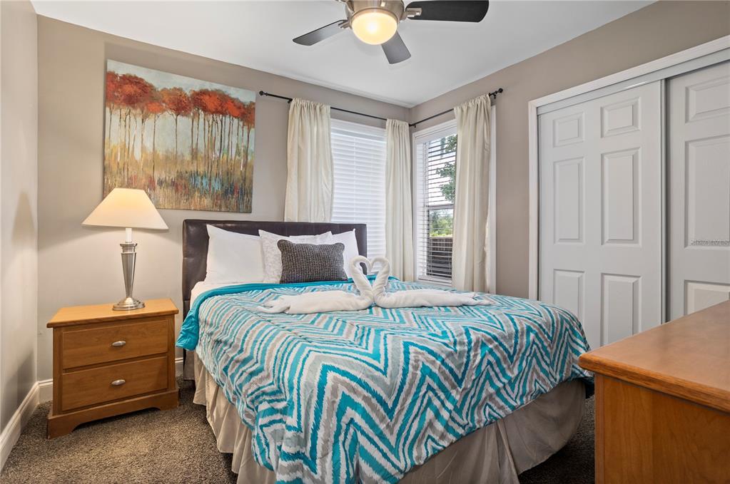 2749 North Poinciana Boulevard, Unit 15 Kissimmee, FL 34746 - Photo 13 of 36 a bedroom with a bed and a chandelier