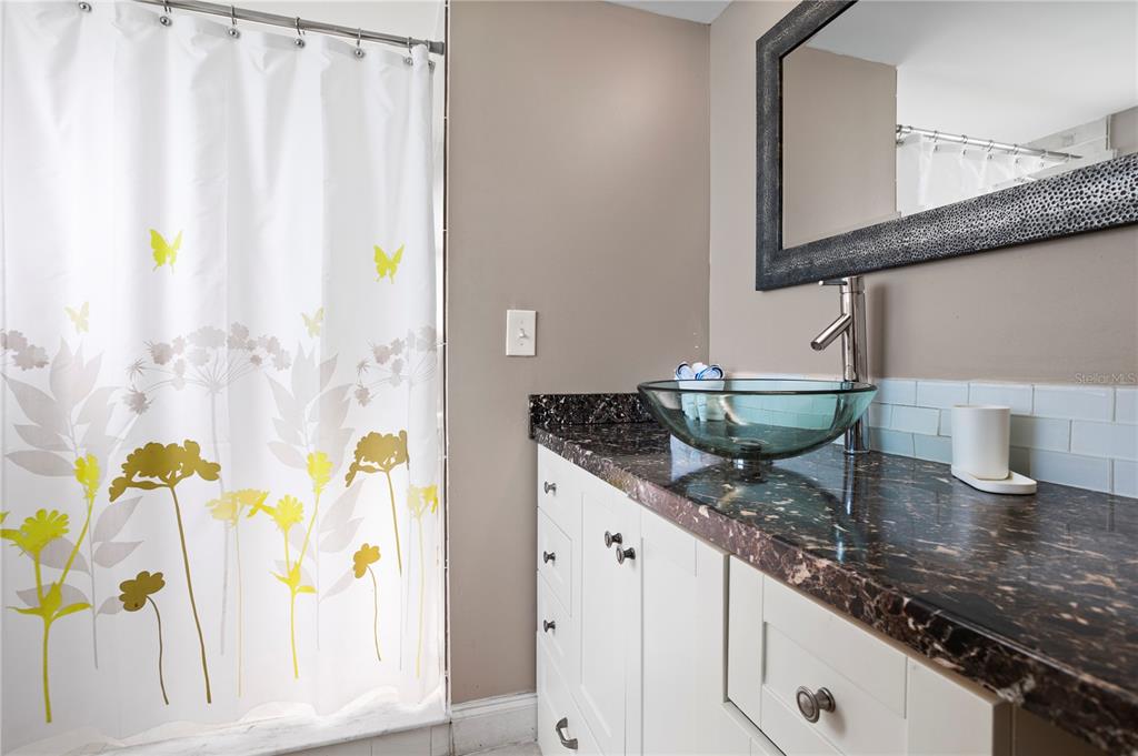 2749 North Poinciana Boulevard, Unit 15 Kissimmee, FL 34746 - Photo 21 of 36 a bathroom with a granite countertop sink and a mirror