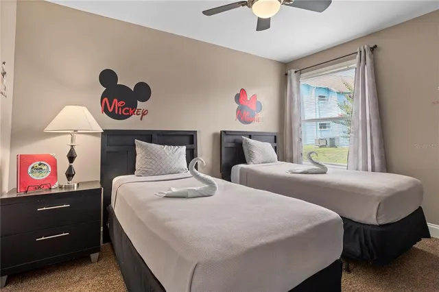 a bedroom with two bed and a chandelier