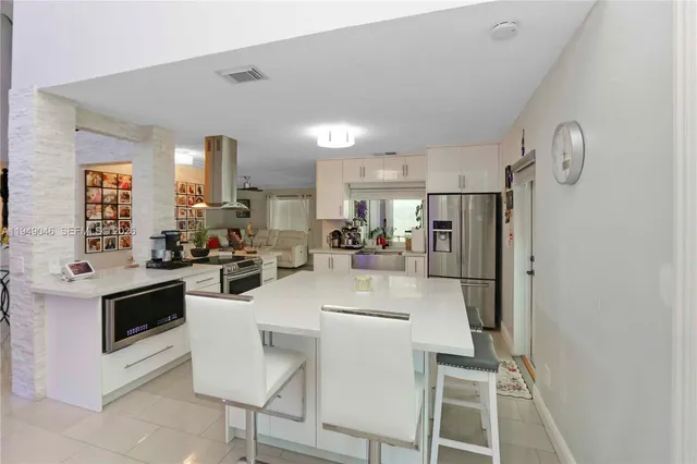 a kitchen with stainless steel appliances a microwave a stove a table and chairs