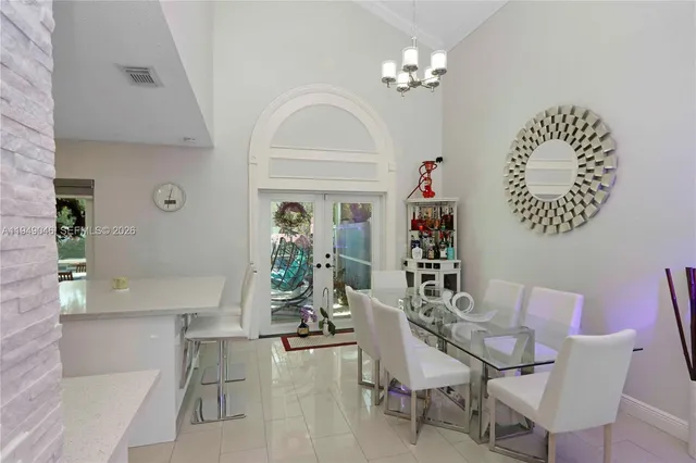 a view of a dining room with furniture a chandelier and wooden floor