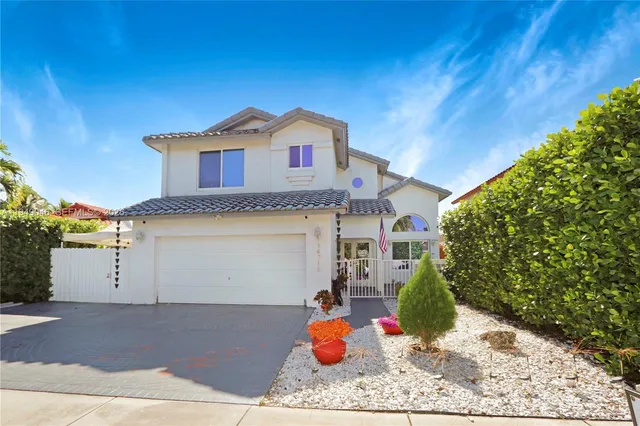 a view of a white house with a yard and plants