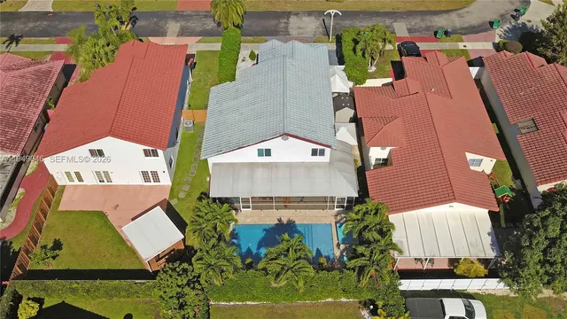 an aerial view of residential houses with outdoor space and parking