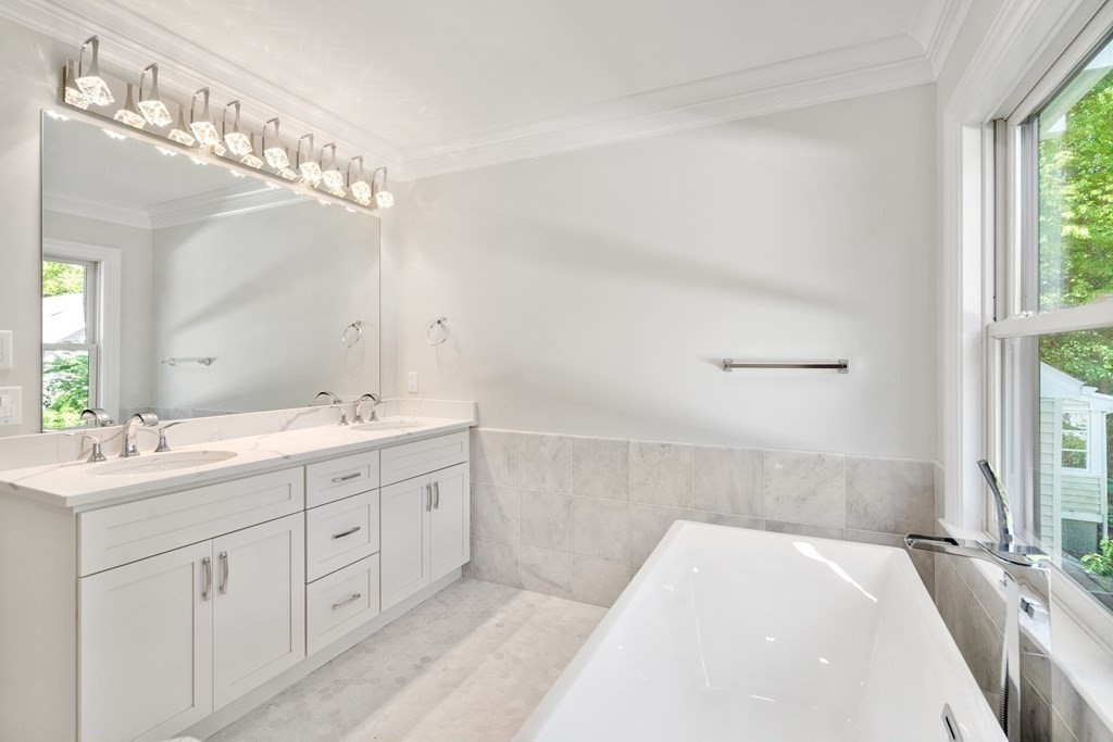 30 Asheville Road Newton, MA 02462 - Photo 11 of 16 a en suite bathroom with a double vanity sink a large mirror and a bathtub