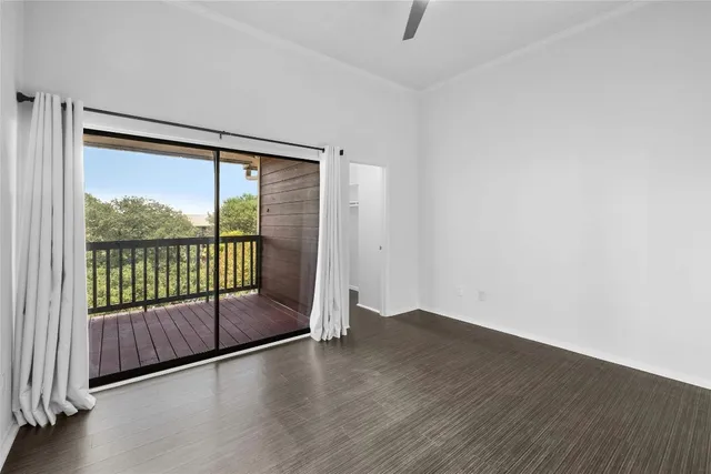 a view of an empty room with wooden floor fireplace and a window