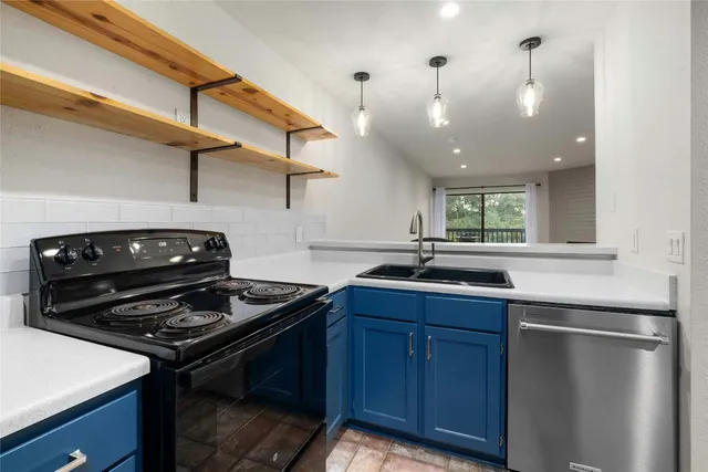 a kitchen with stainless steel appliances granite countertop a stove and a refrigerator