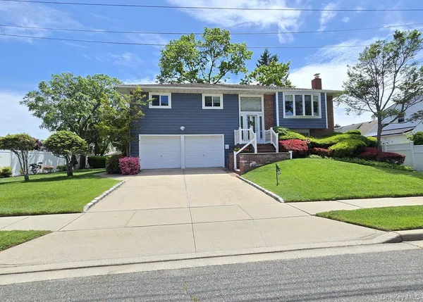 a front view of a house with a yard and potted plants