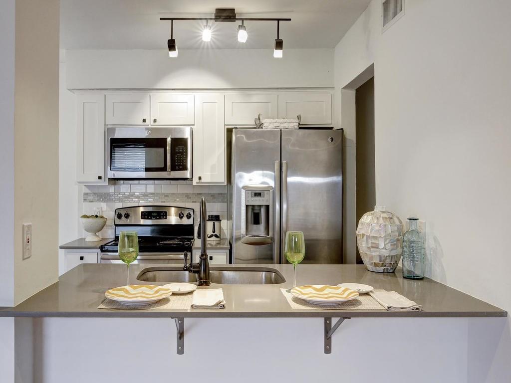 3500 Alpine Circle, Unit 1 Austin, TX 78704 - Photo 12 of 20 a kitchen with stainless steel appliances granite countertop a refrigerator a stove top oven a sink and dishwasher