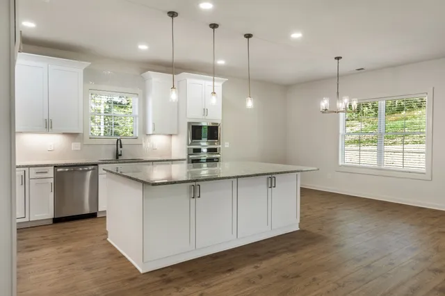 a kitchen with kitchen island a sink stainless steel appliances and cabinets