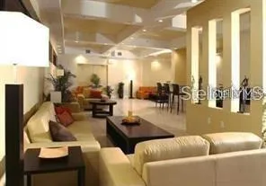 a living room with couches and a dining table with kitchen view