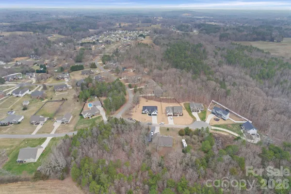 an empty room with wooden floor closet and windows