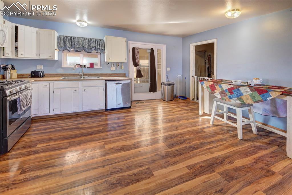 369 G Street Penrose, CO 81240 - Photo 11 of 37 a kitchen with stainless steel appliances granite countertop a sink cabinets and wooden floor