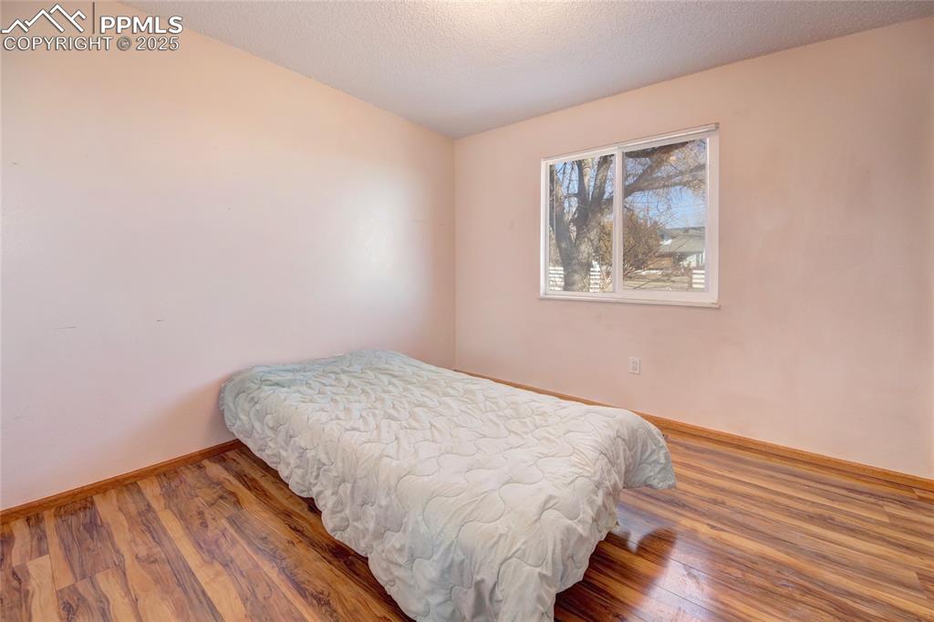 369 G Street Penrose, CO 81240 - Photo 17 of 37 a bedroom with a bed and wooden floor