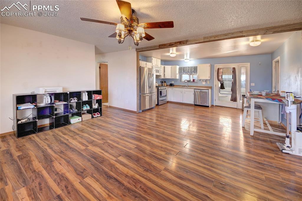 369 G Street Penrose, CO 81240 - Photo 9 of 37 a view of a living room and kitchen with furniture and wooden floor