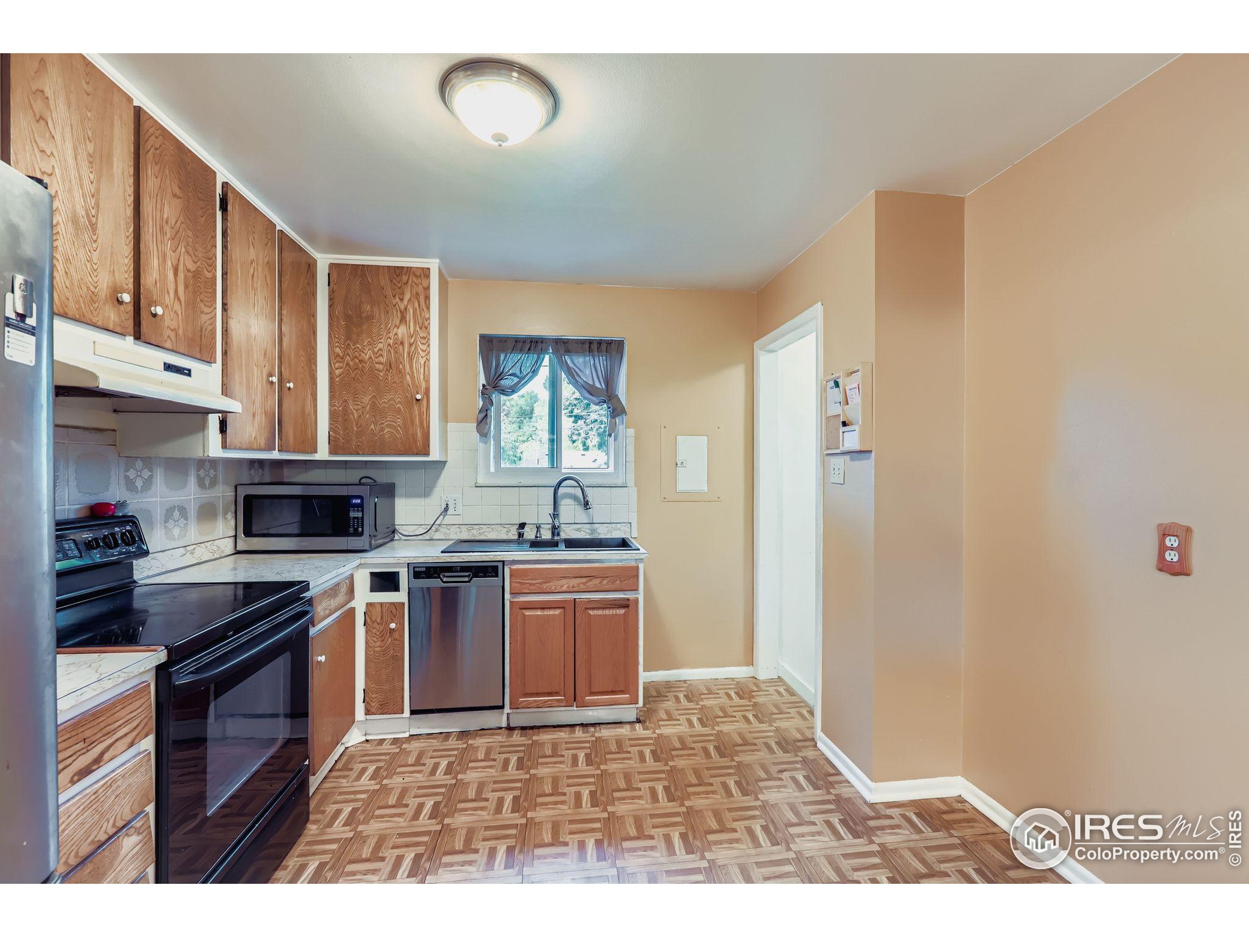 11816 Spring Drive Northglenn, CO 80233 - Photo 3 of 10 a kitchen with stainless steel appliances granite countertop a stove a sink and a refrigerator