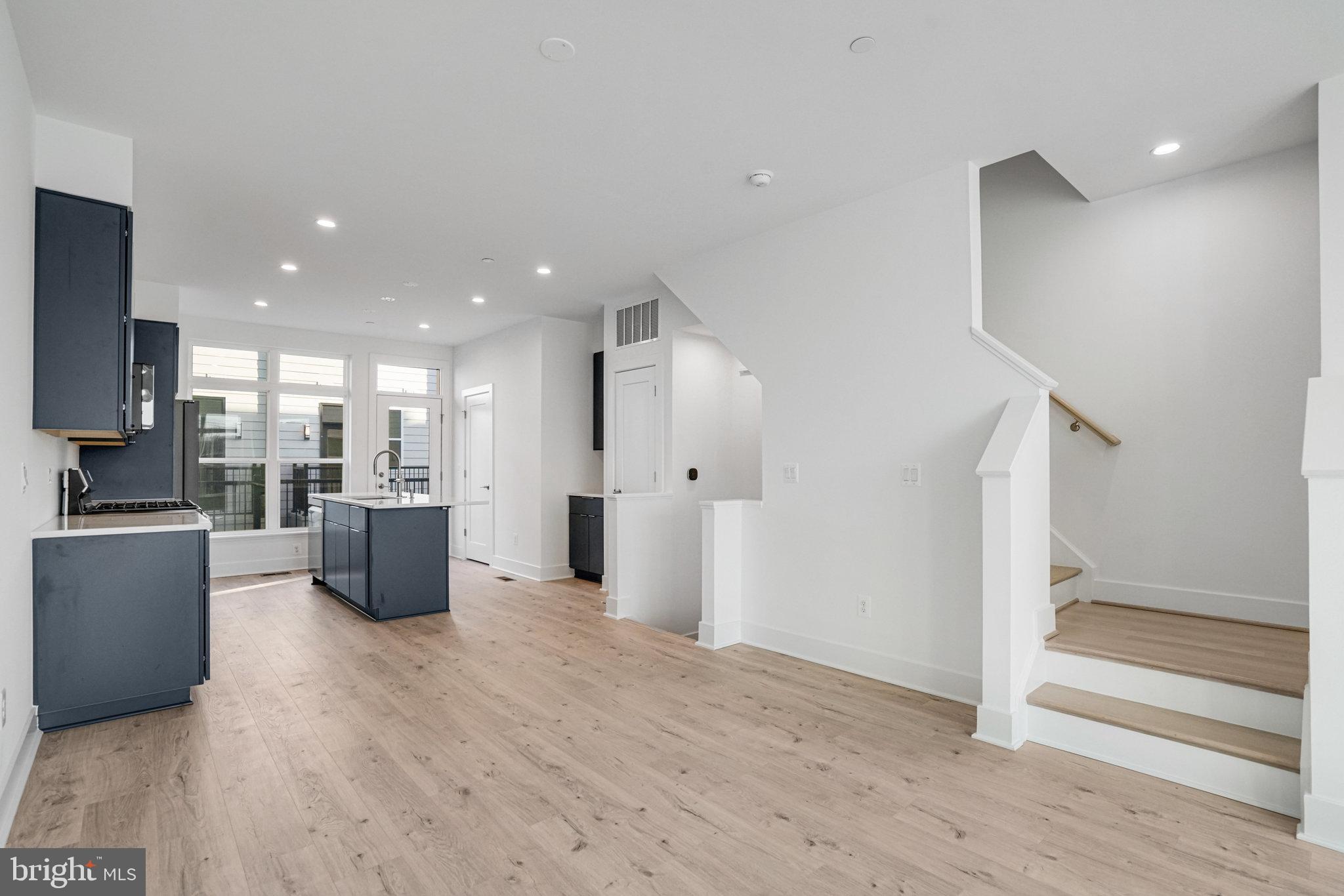 2058 Tysons Ridgeline Road Falls Church, VA 22043 - Photo 14 of 48 a view of kitchen with stainless steel appliances kitchen island wooden floor and living room