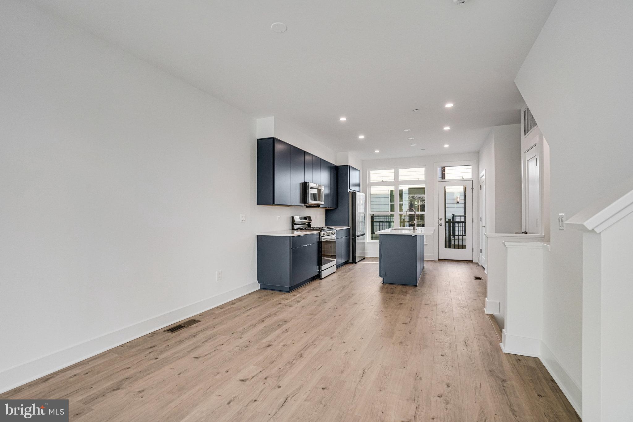 2058 Tysons Ridgeline Road Falls Church, VA 22043 - Photo 15 of 48 a kitchen with stainless steel appliances a refrigerator a sink dishwasher with a oven and wooden floor