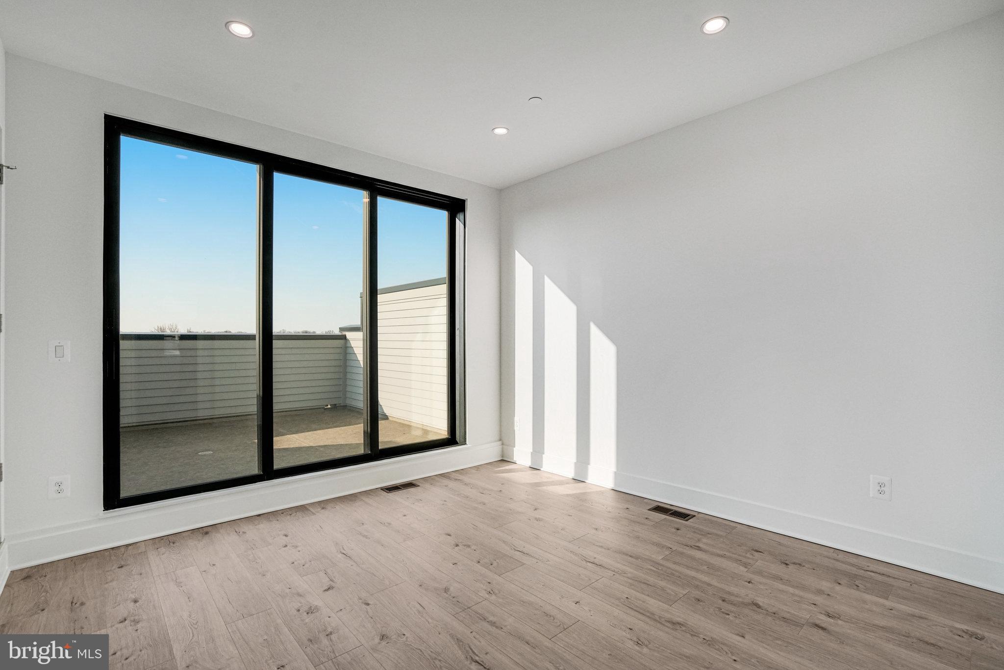 2058 Tysons Ridgeline Road Falls Church, VA 22043 - Photo 30 of 48 an empty room with wooden floor and sliding door