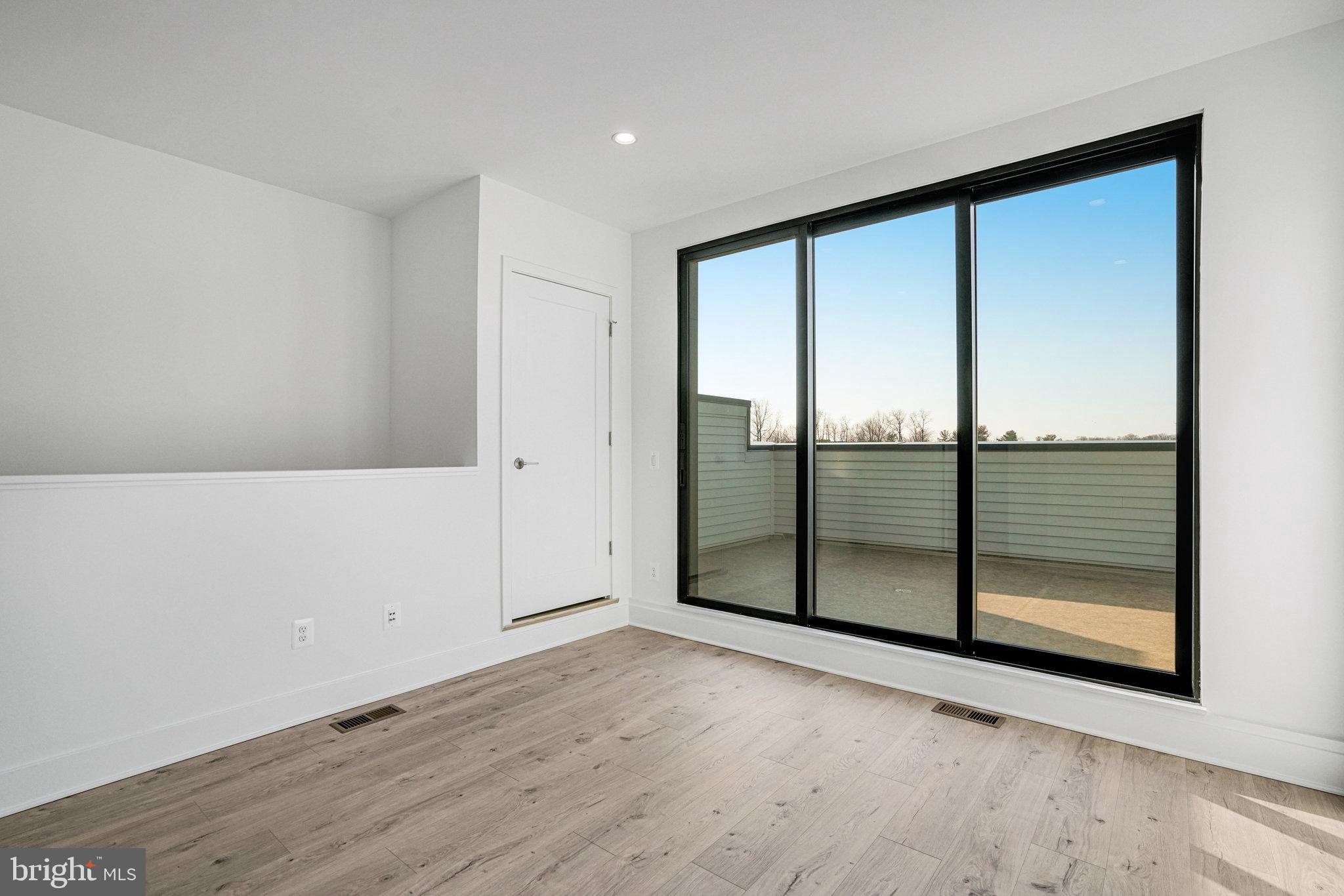 2058 Tysons Ridgeline Road Falls Church, VA 22043 - Photo 32 of 48 an empty room with wooden floor and sliding door
