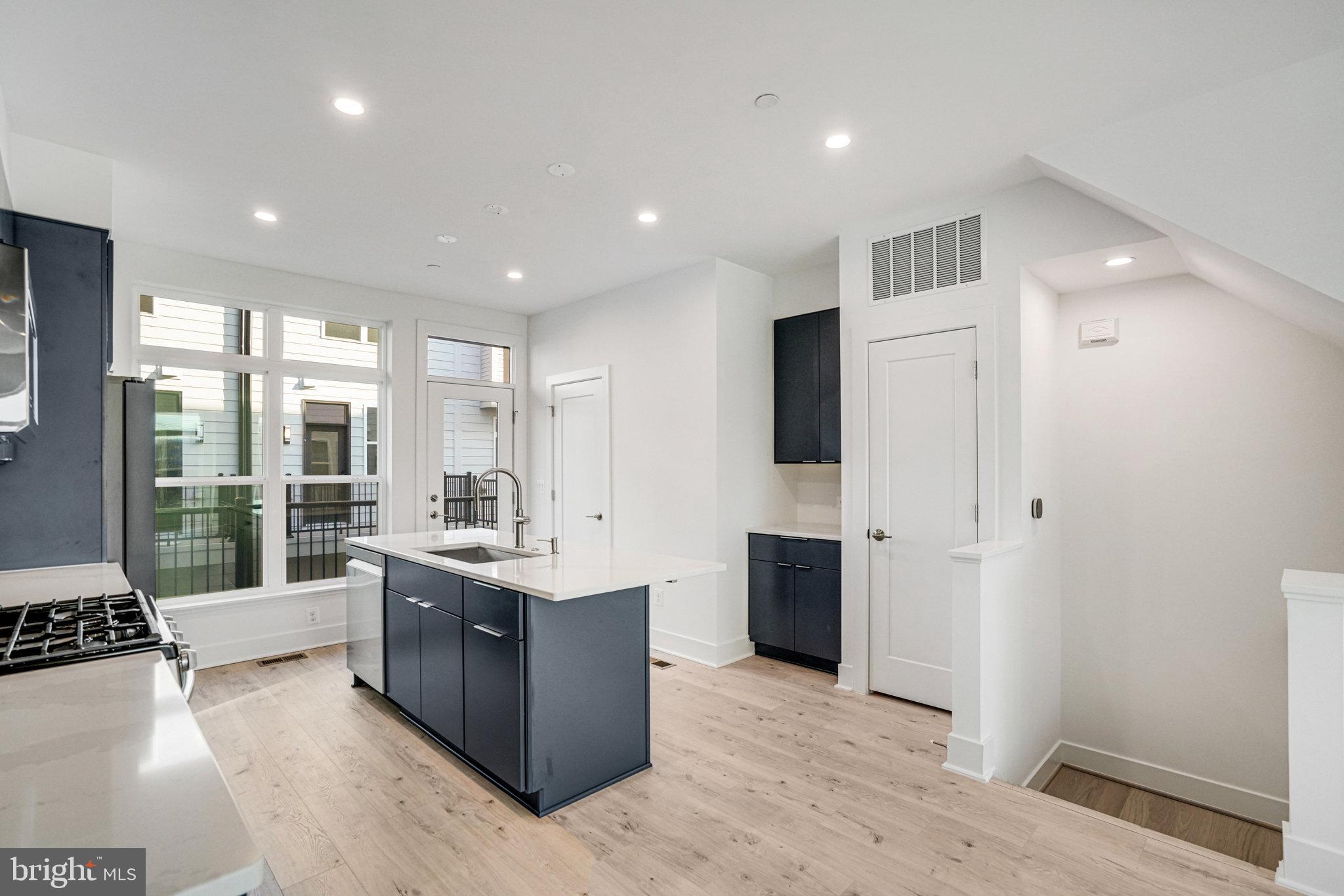 2058 Tysons Ridgeline Road Falls Church, VA 22043 - Photo 7 of 48 a large kitchen with stainless steel appliances kitchen island granite countertop a refrigerator and a stove top oven