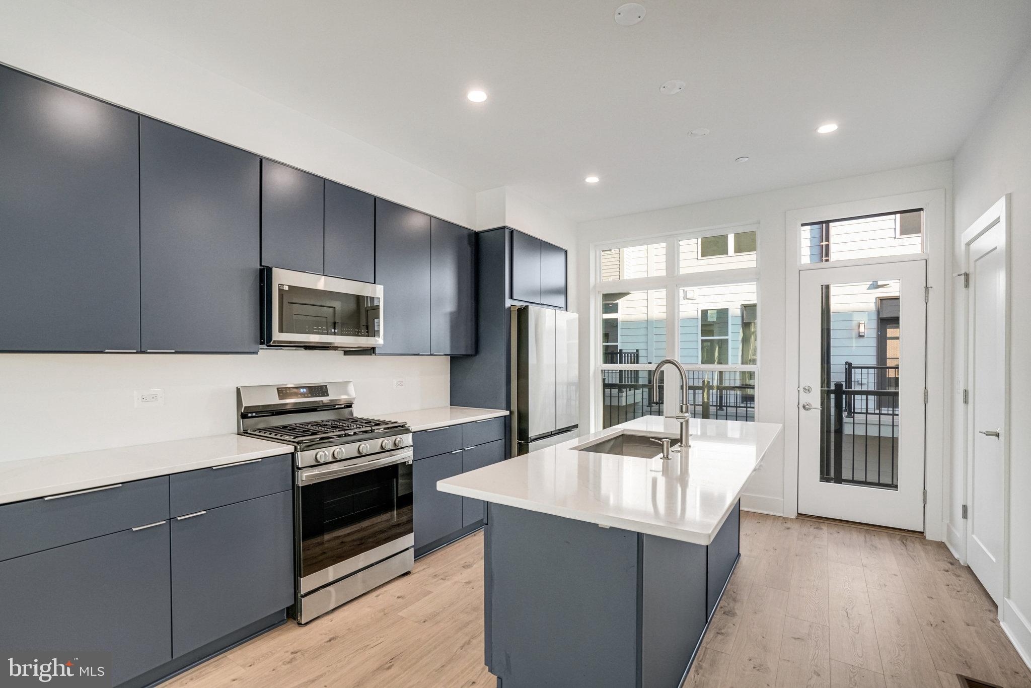 2058 Tysons Ridgeline Road Falls Church, VA 22043 - Photo 8 of 48 a kitchen with stainless steel appliances a stove a sink a microwave a refrigerator and cabinets