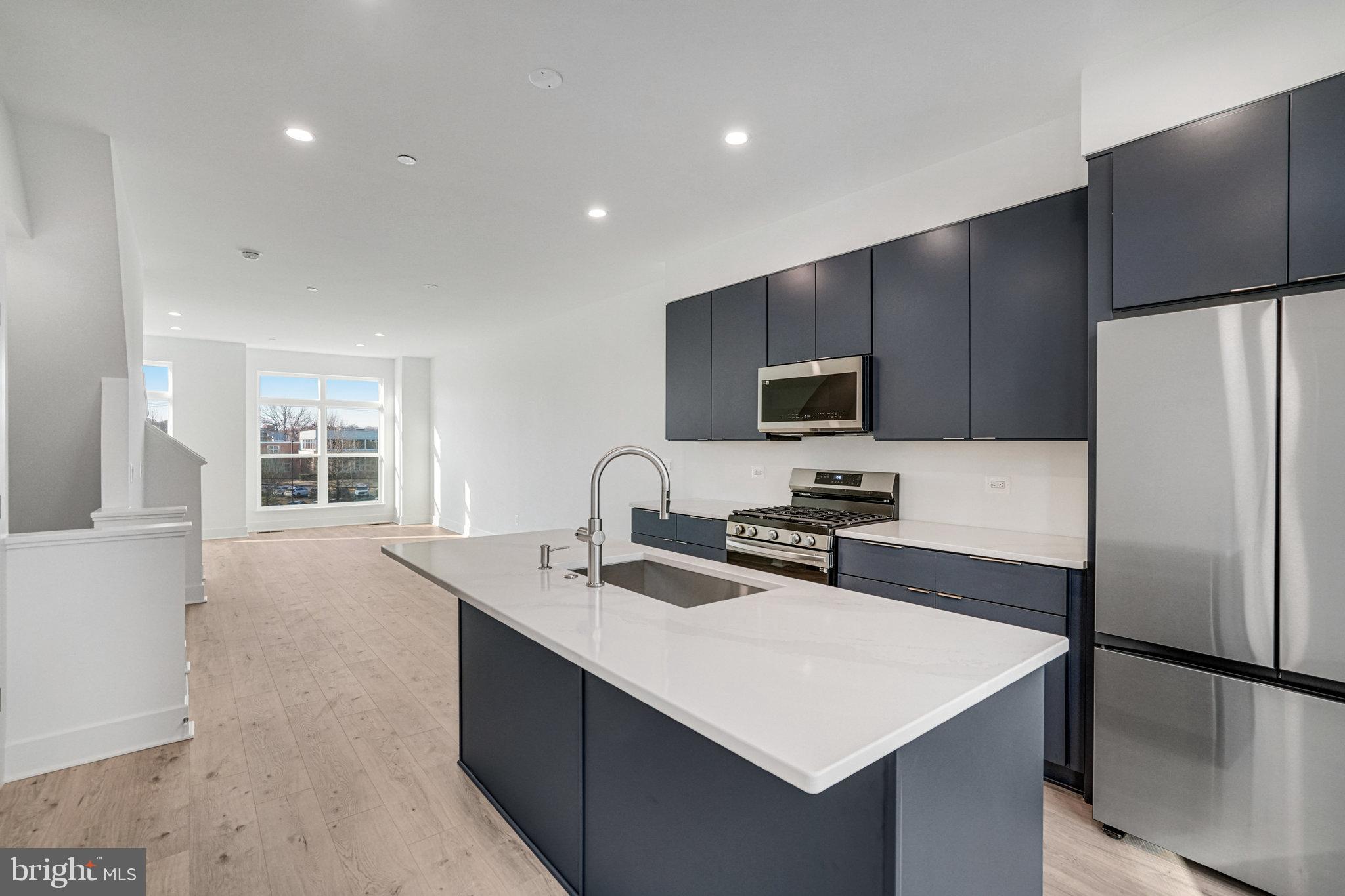 2058 Tysons Ridgeline Road Falls Church, VA 22043 - Photo 10 of 48 a kitchen with a sink a center island stainless steel appliances and cabinets