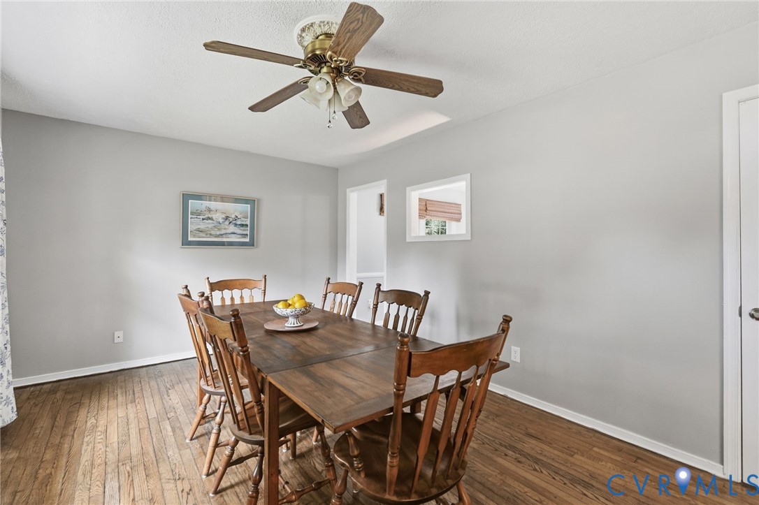 Hardwood flooring, painted walls, ceiling fan, and
